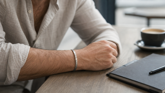 Man wearing a hammered titanium cuff bracelet at a cafe