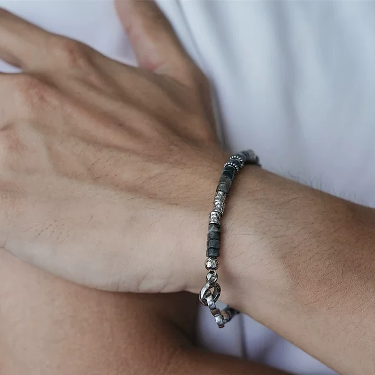 Close view of black-gray beaded bracelet worn on a wrist